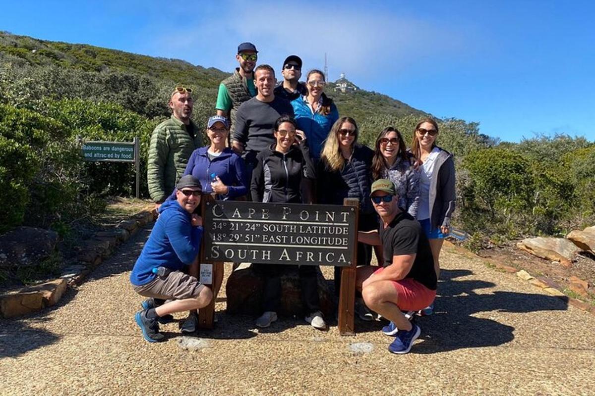 um grupo de pessoas em pé ao lado de uma placa