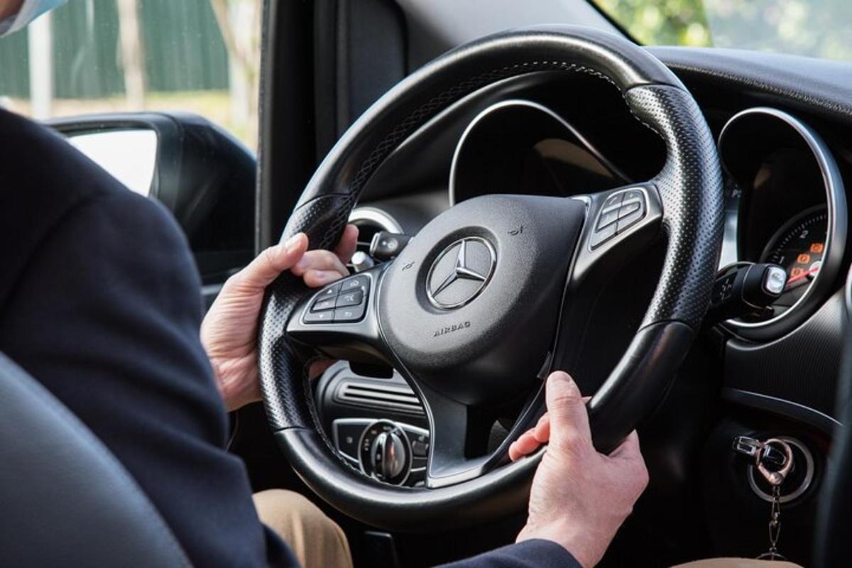 osoba řídící auto s volantem