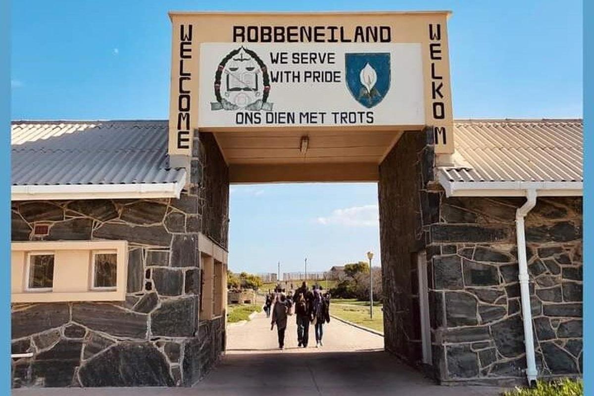 a group of people walking through a building with a sign