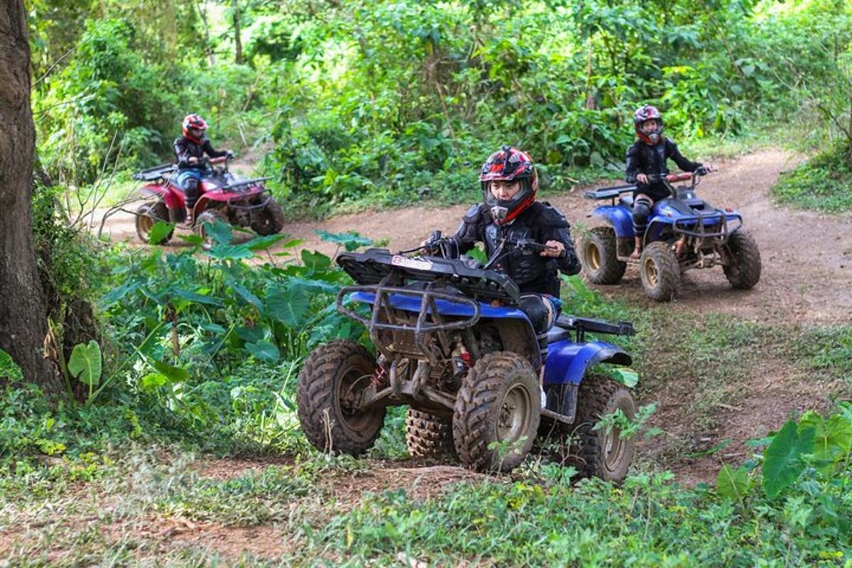 tres persones que viatgen en quads per un camí de terra