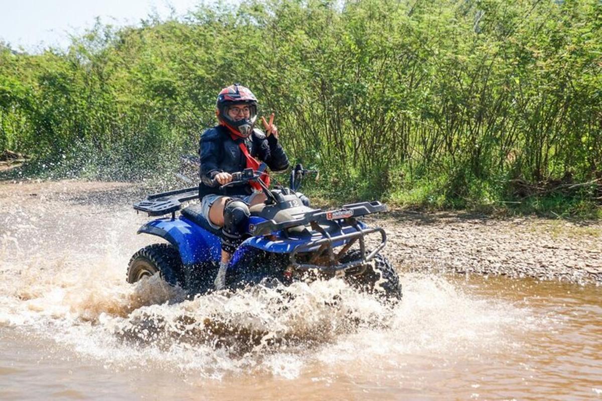una persona che guida un quad attraverso l'acqua