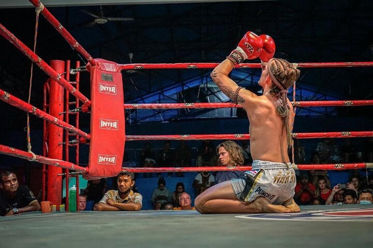 um homem em uma luta de boxe na frente de uma multidão