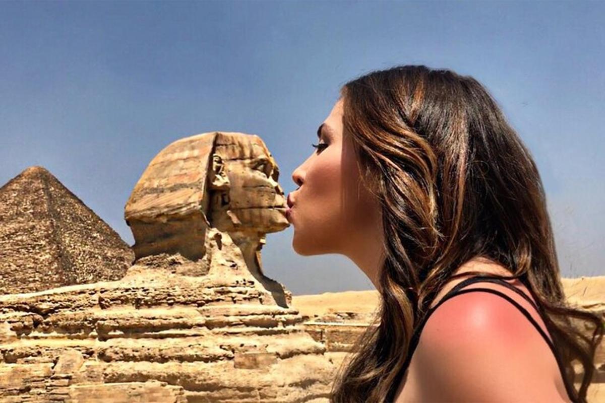 Žena líbá sfingu u pyramid