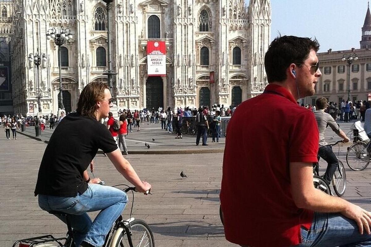 zwei Männer fahren Fahrrad vor einem Gebäude