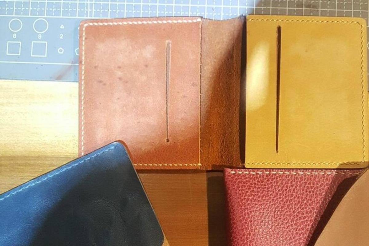 tre libri in pelle appoggiati su un tavolo con un computer portatile