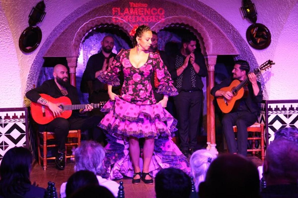 una dona amb un vestit rosa dempeus en un escenari