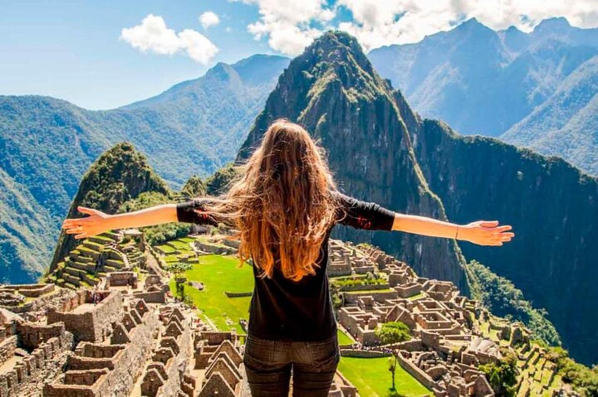 Egy nő áll a Machu Picchu romjai tetején