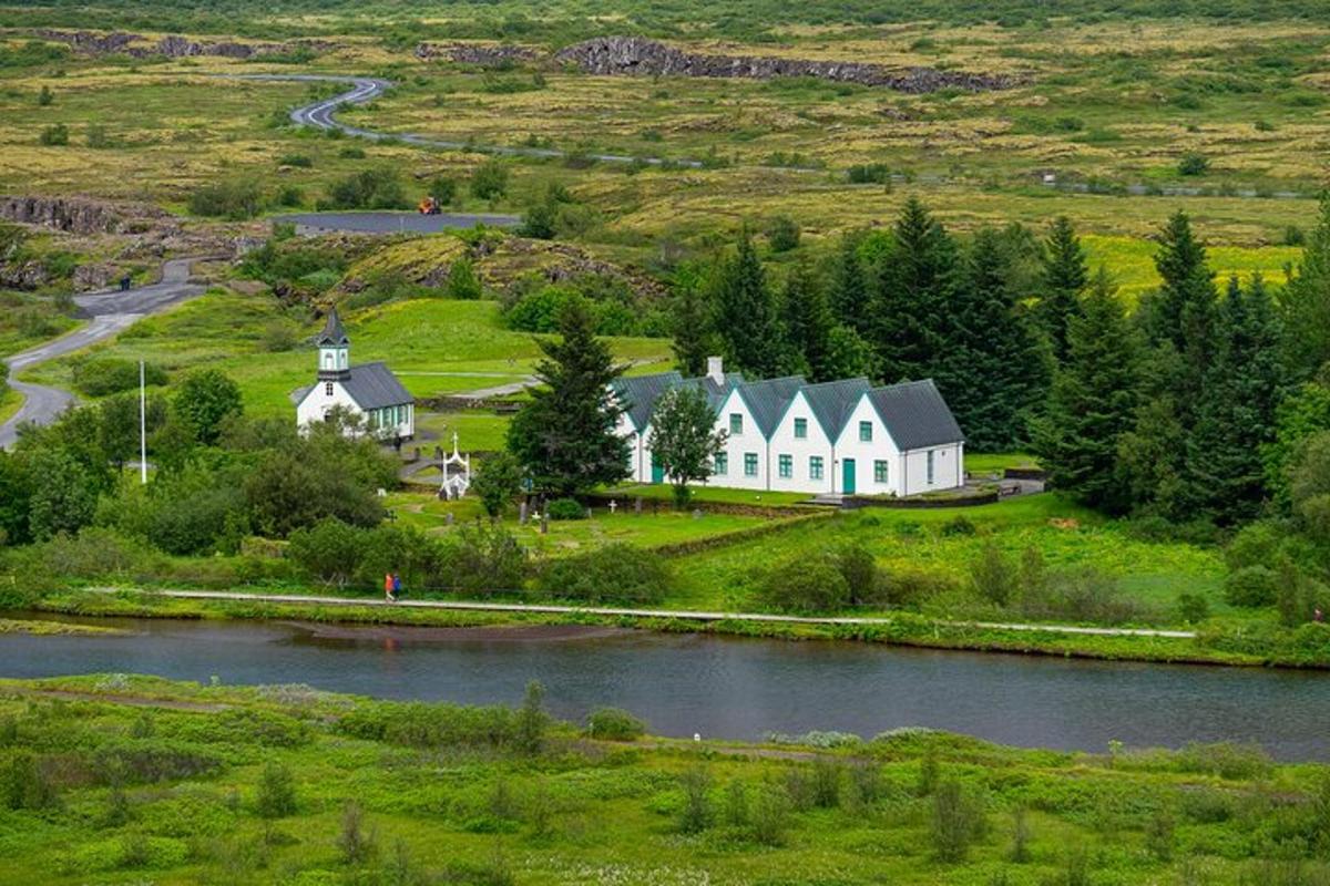 Loftmynd af húsi á túni við ána