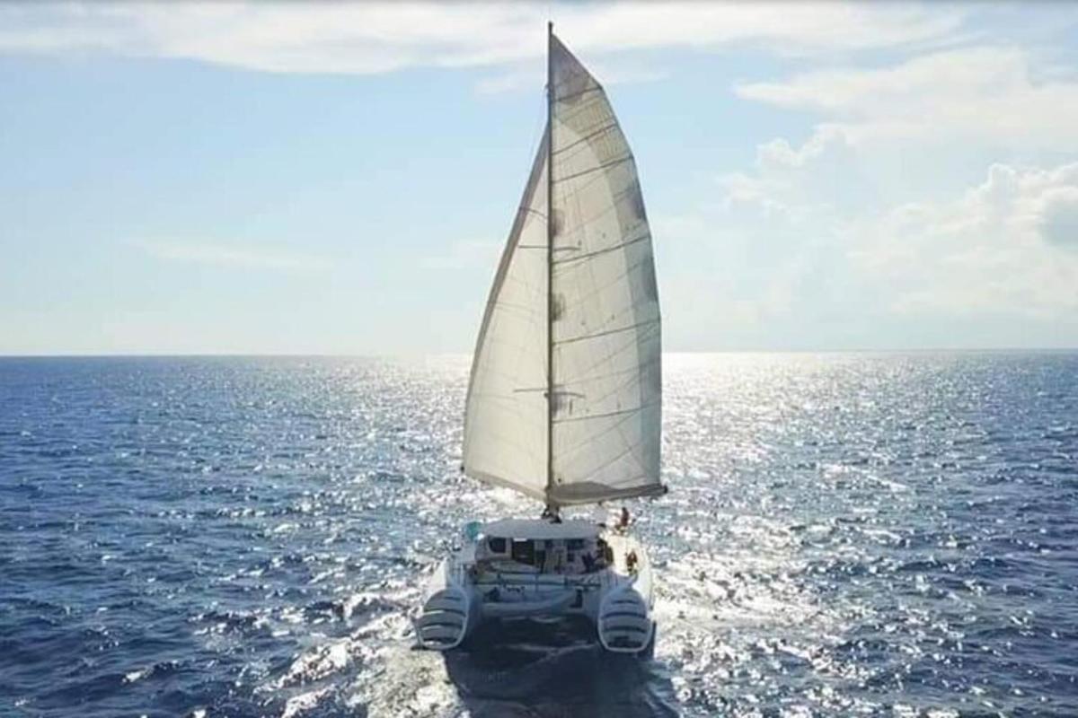 isang bangka na may puting layag sa karagatan