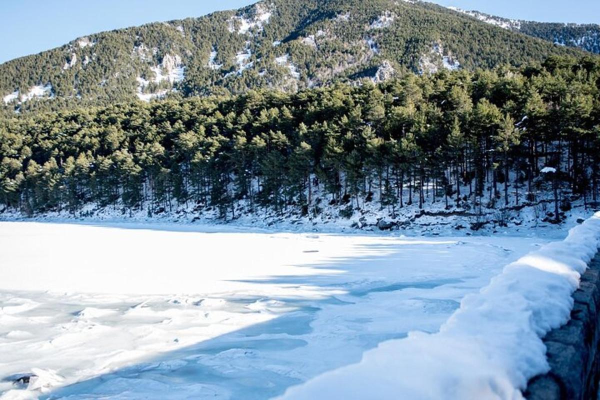 una vista d'un riu cobert de neu amb una muntanya