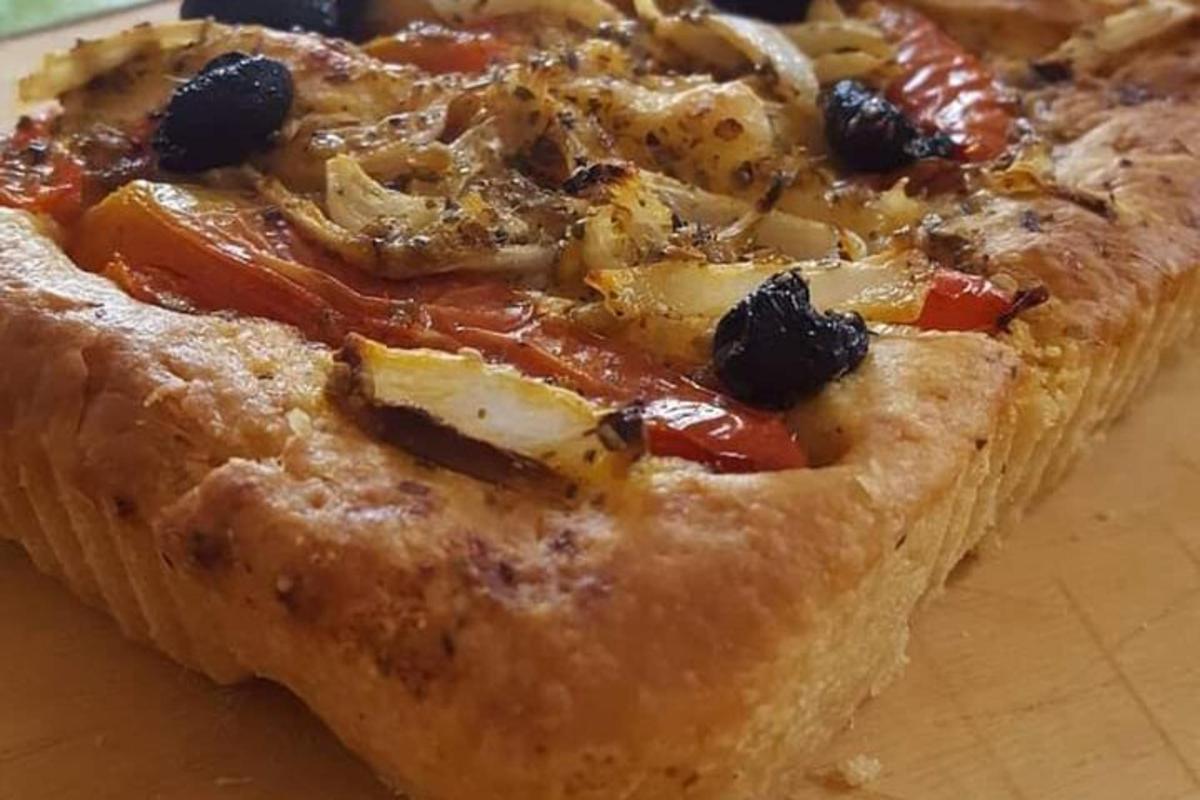 en pizza som står på toppen av et trebord