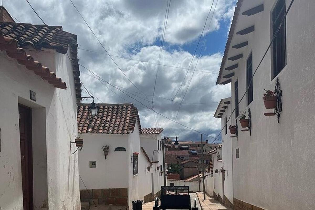 an alley with white buildings and a cloudy sky