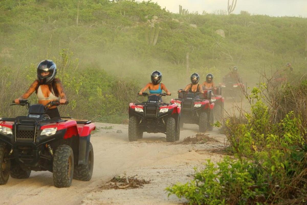 un gruppo di persone che guidano quad su una strada sterrata