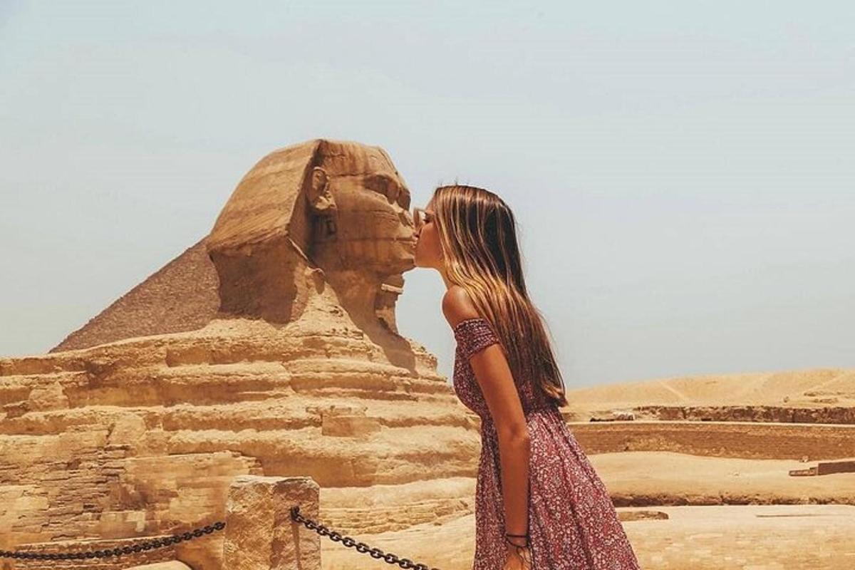 a woman standing in front of the sphinx