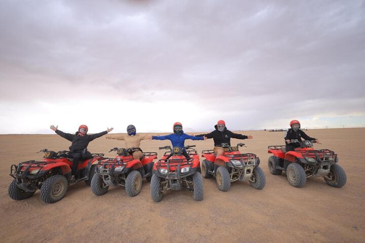 sekumpulan orang di atv di padang pasir