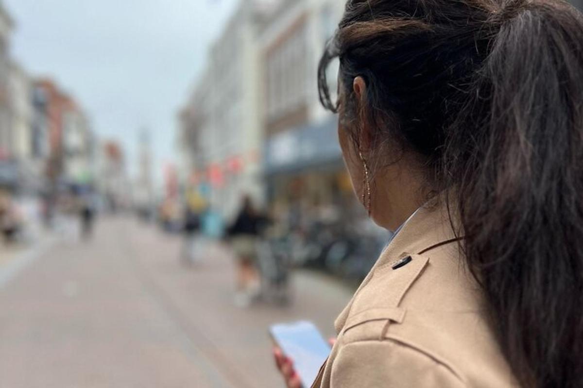 naine vaatab linnatänaval oma mobiiltelefoni