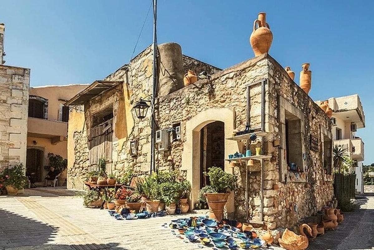 ένα πέτρινο κτίριο με γλάστρες με φυτά μπροστά του