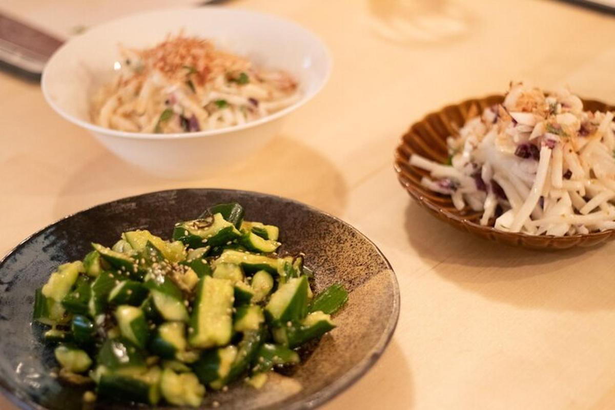 a table with two bowls of food and a bowl of pasta