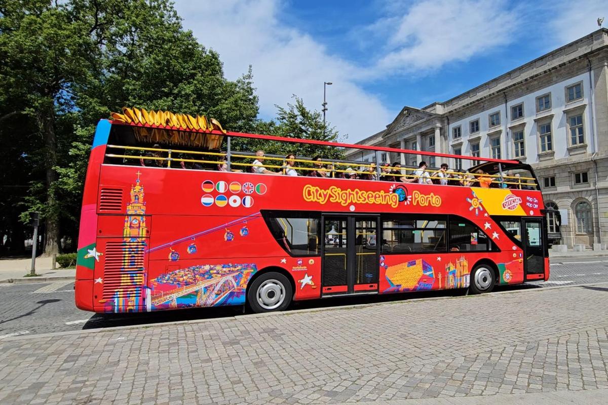 czerwony piętrowy autobus jadący ulicą