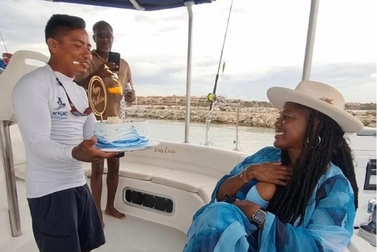 un uomo che tiene in braccio una donna che tiene in mano una torta su una barca
