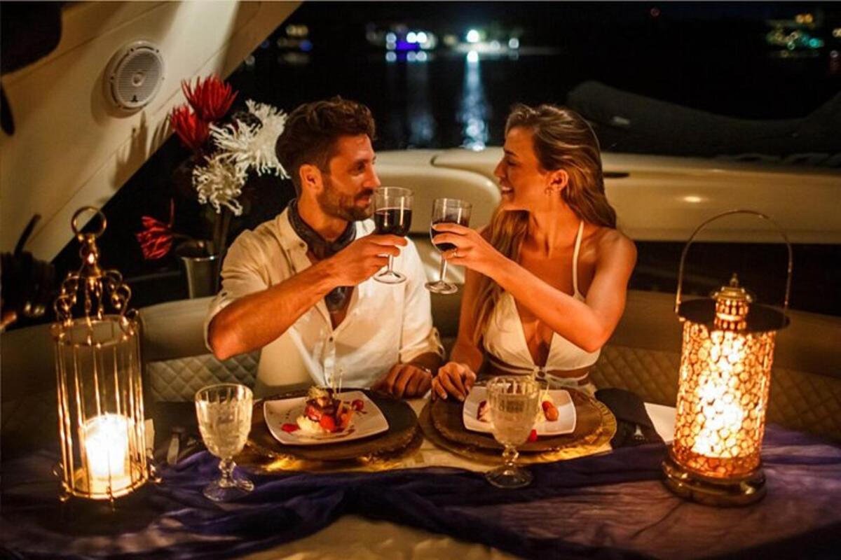 un bărbat și o femeie așezați la o masă cu pahare de vin