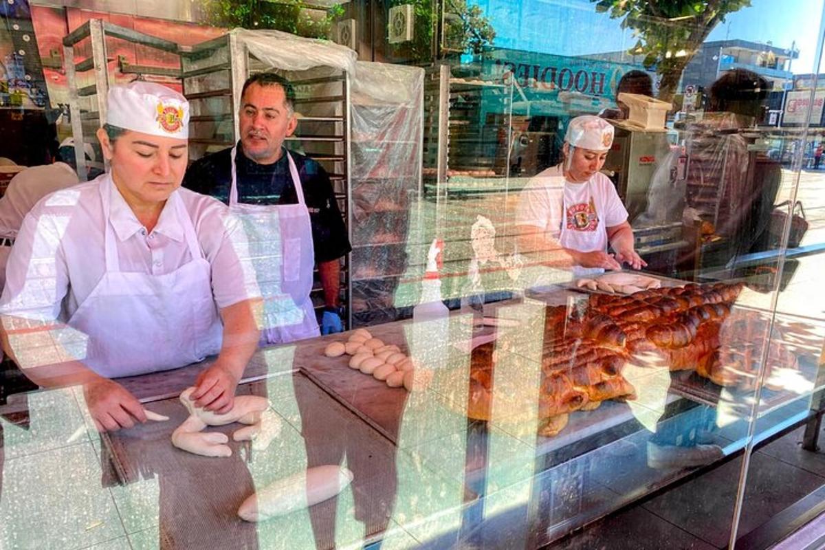 a group of men standing behind a counter with food