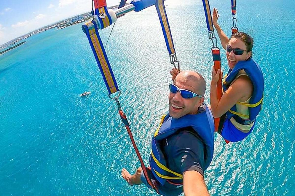 a man and woman on a zip line in the water