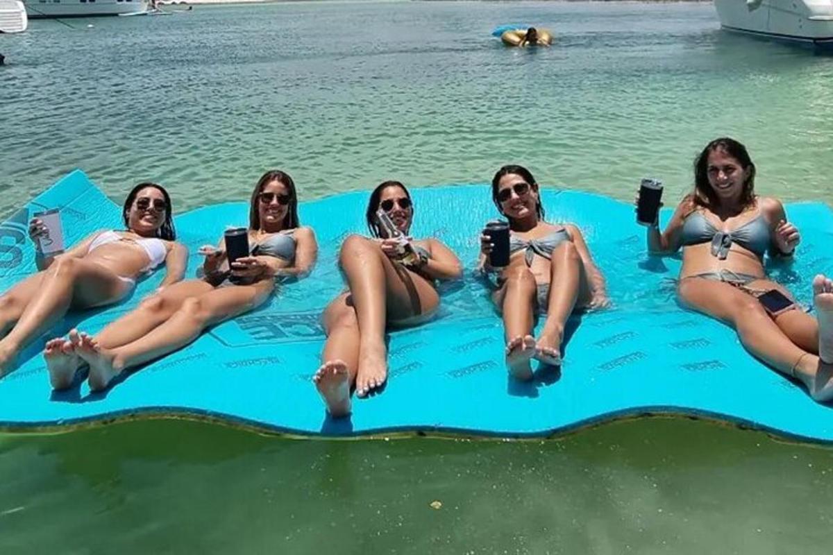 Hópur kvenna situr í uppblásinni sundlaug í vatninu