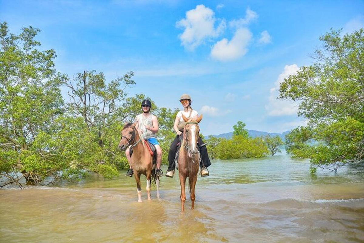Dos personas montan a caballo por un río.