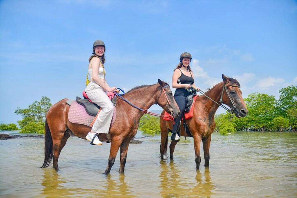 Dos mujeres montan a caballo en el agua.