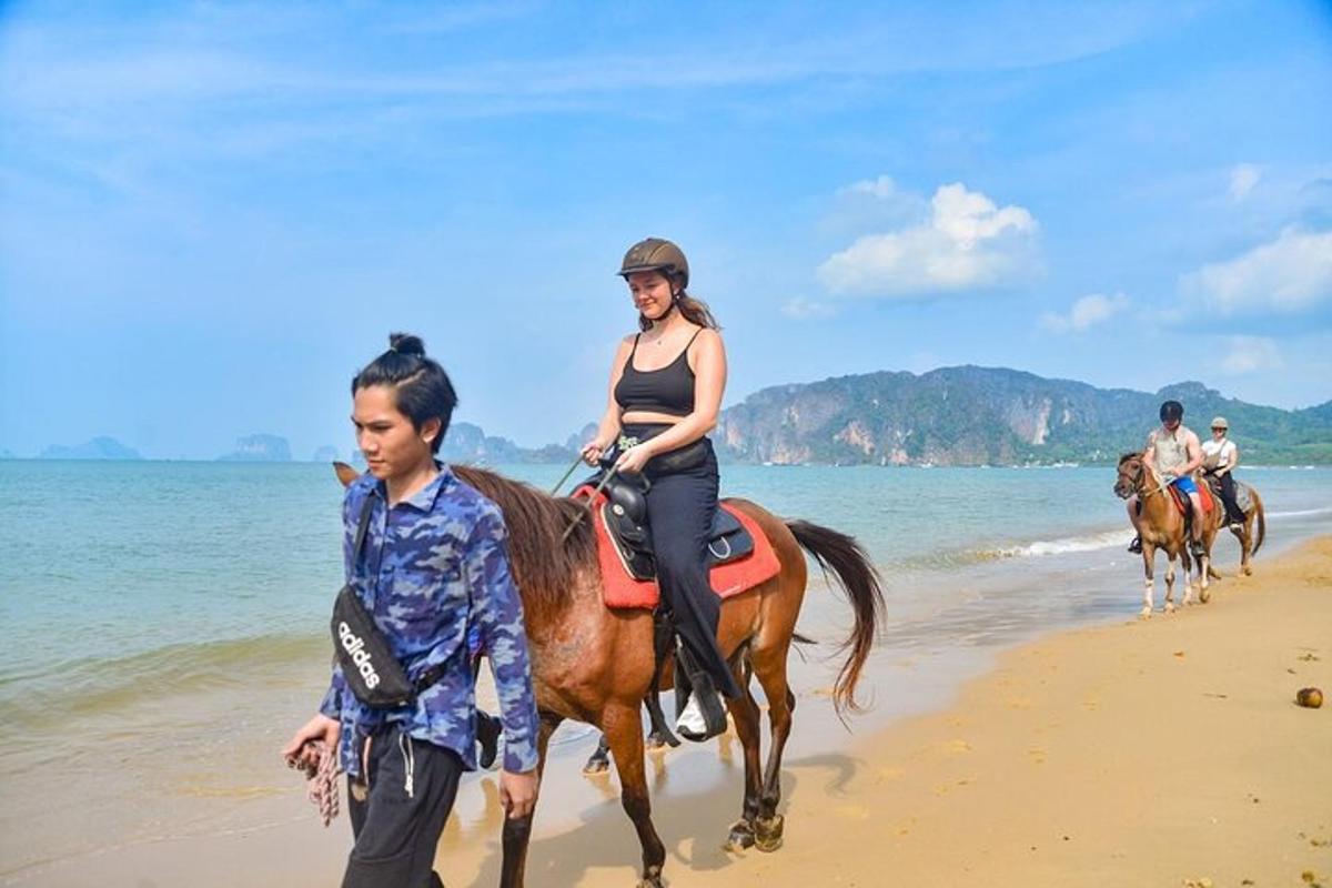 un grupo de personas montando a caballo en la playa