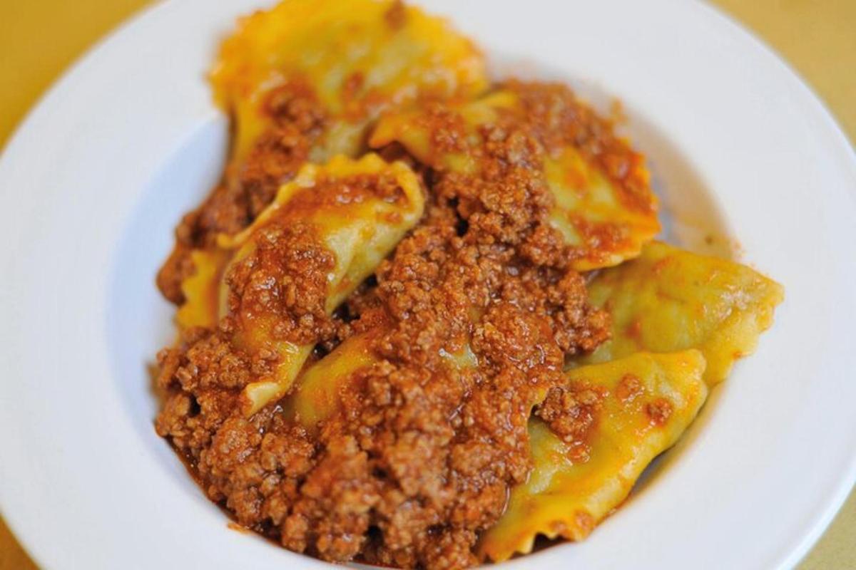 a white plate of food with meat and cheese