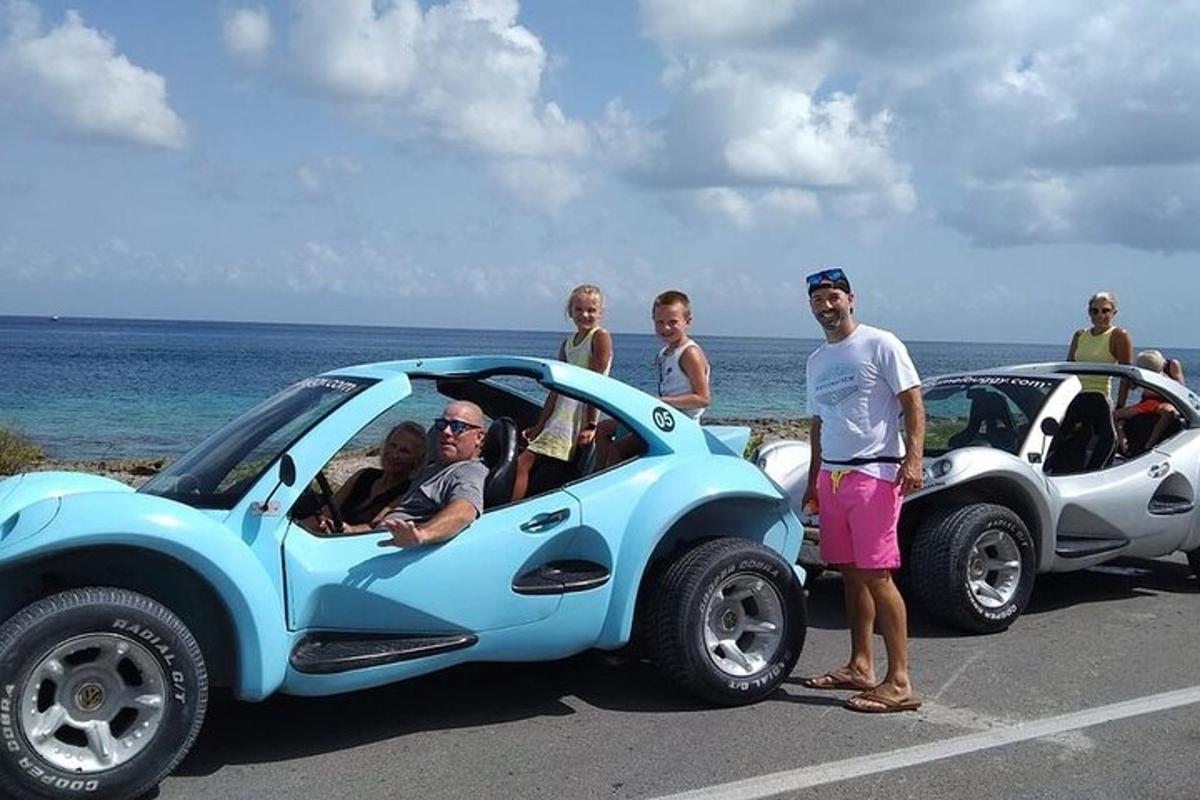 grupė žmonių, stovinčių šalia mažo automobilio