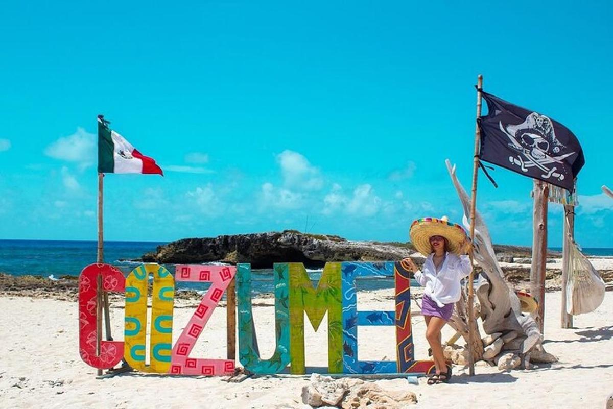 Una mujer parada junto a un cartel en la playa.