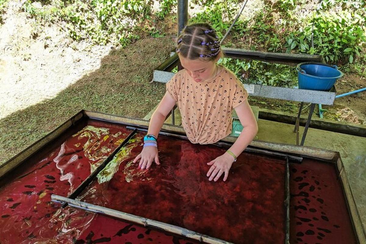a young girl is looking into a pool of red liquid