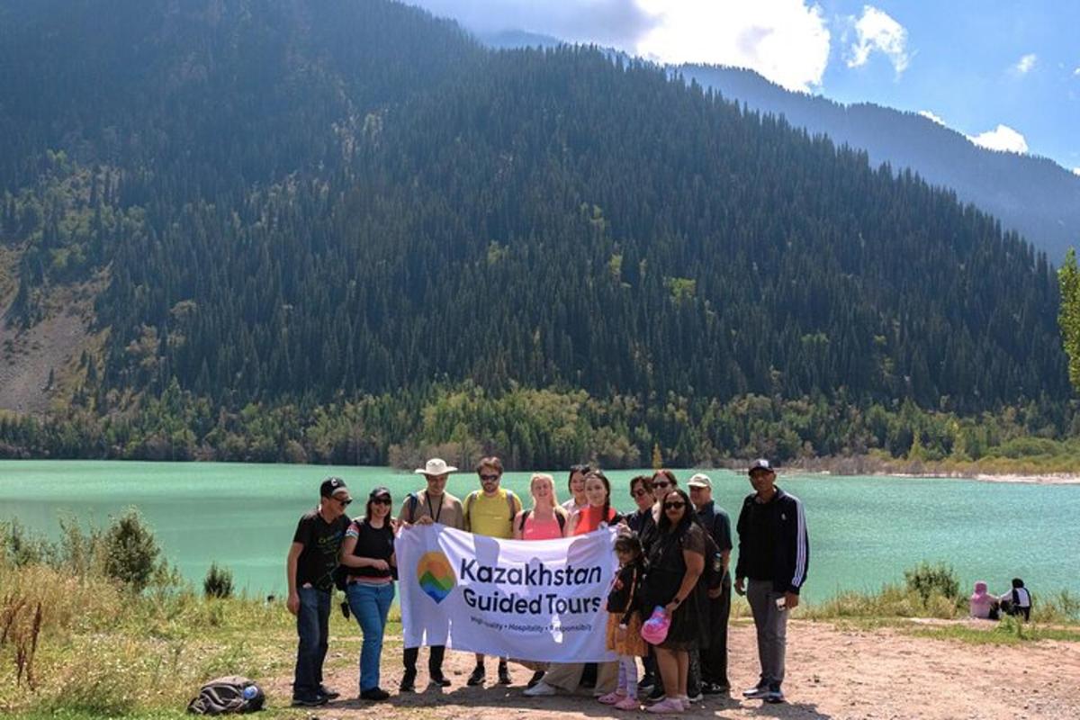 a group of people holding a banner in front of a lake