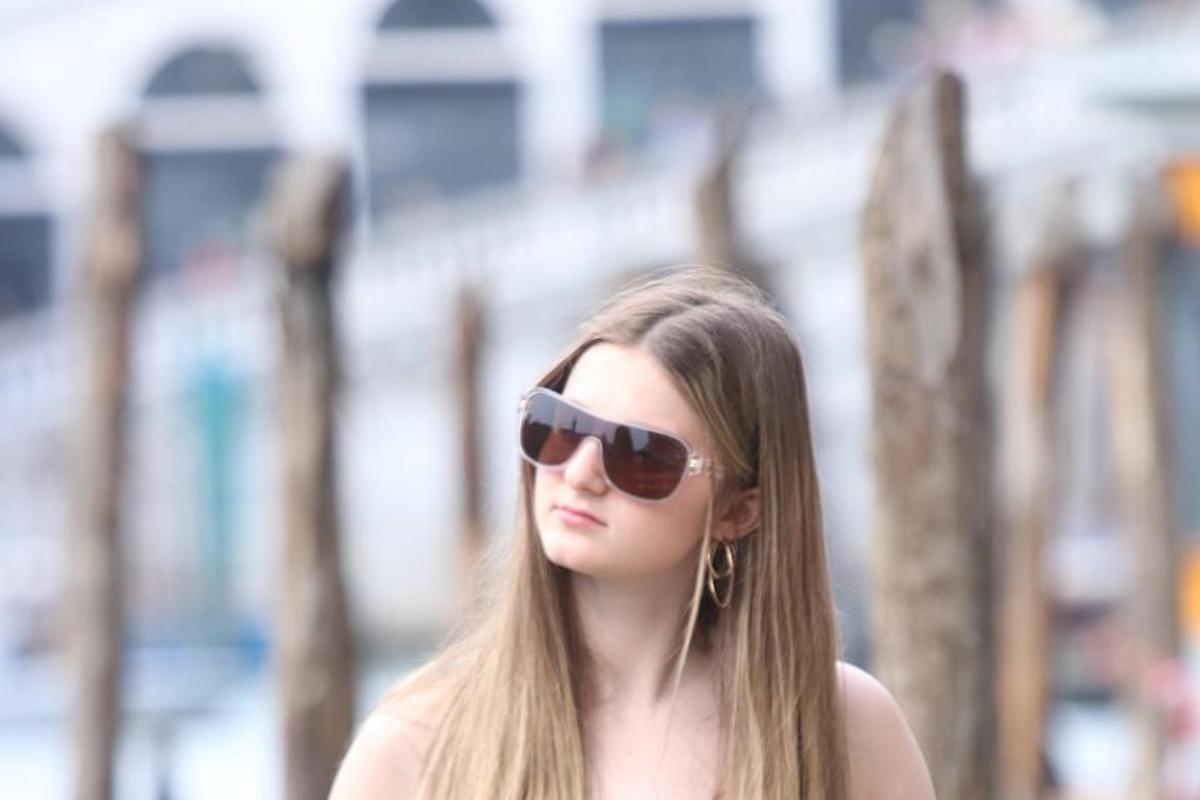 mladá žena se slunečními brýlemi a poslouchá hudbu
