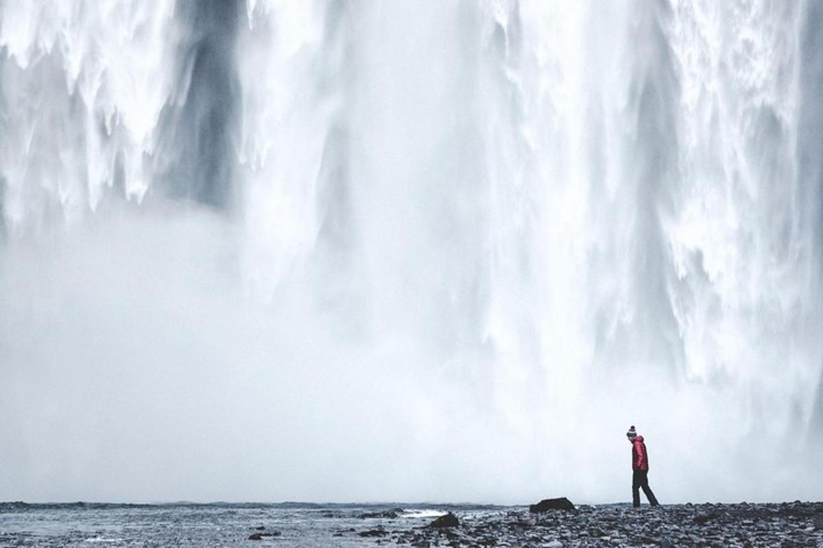 a man standing in front of a waterfall