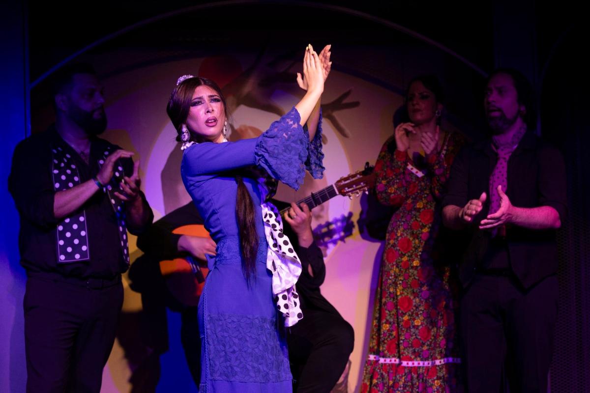 a woman dancing on a stage with a group of people
