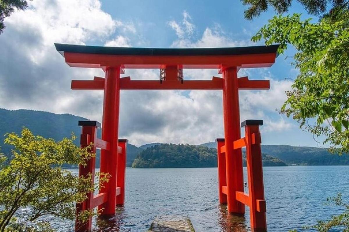 Egy narancssárga torii kapu egy tó közepén