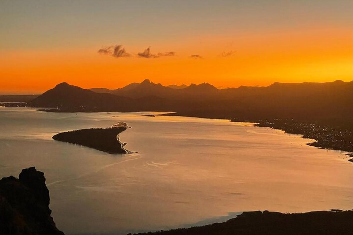 una gran massa d'aigua amb una posta de sol al fons