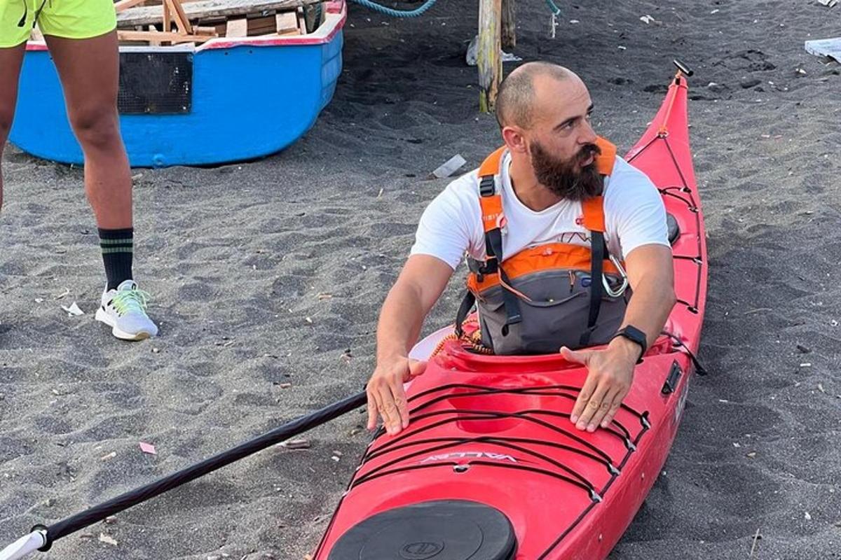 a man is sitting on a red kayak