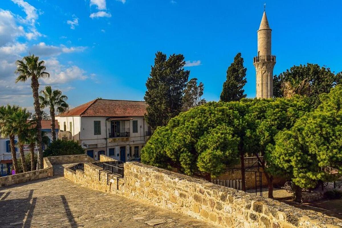 um edifício com uma torre de relógio e um muro de pedra