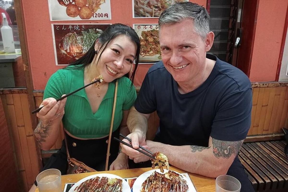 a man and a woman sitting at a table with chopsticks