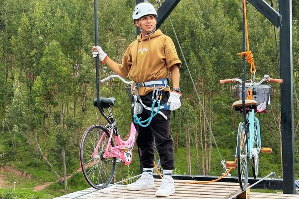 isang lalaking nakatayo sa isang zip line na may bisikleta