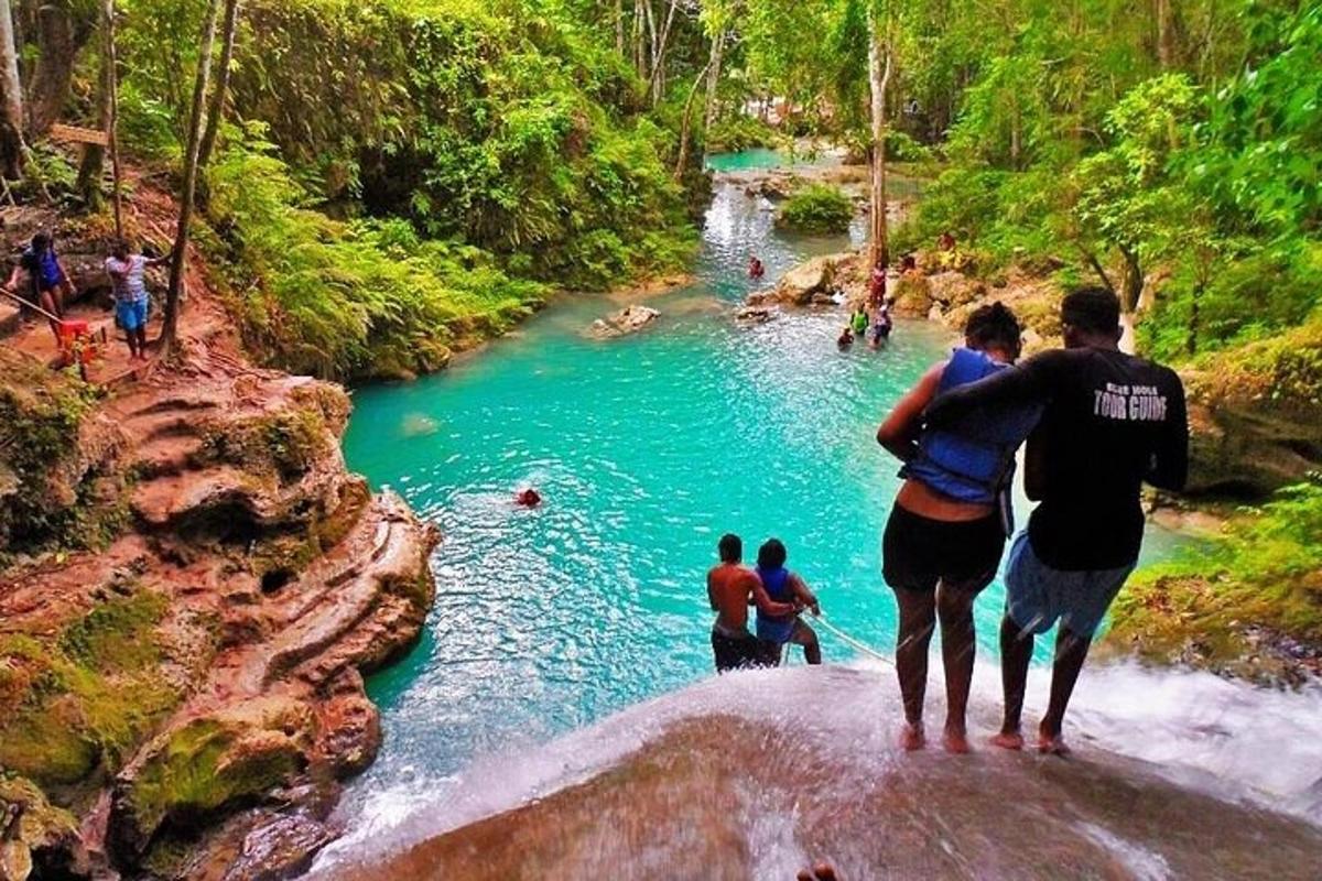 un gruppo di persone in piedi su una roccia vicino a un fiume