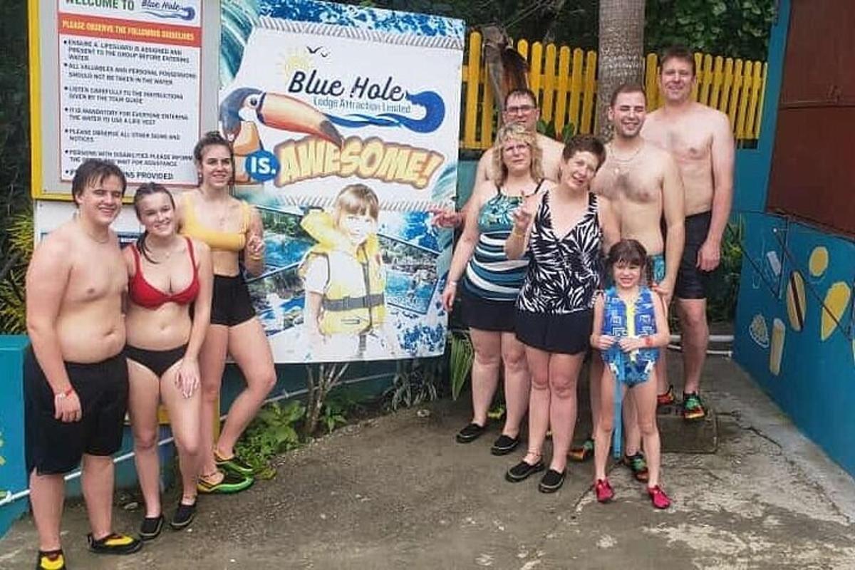 skupina lidí stojící před cedulí