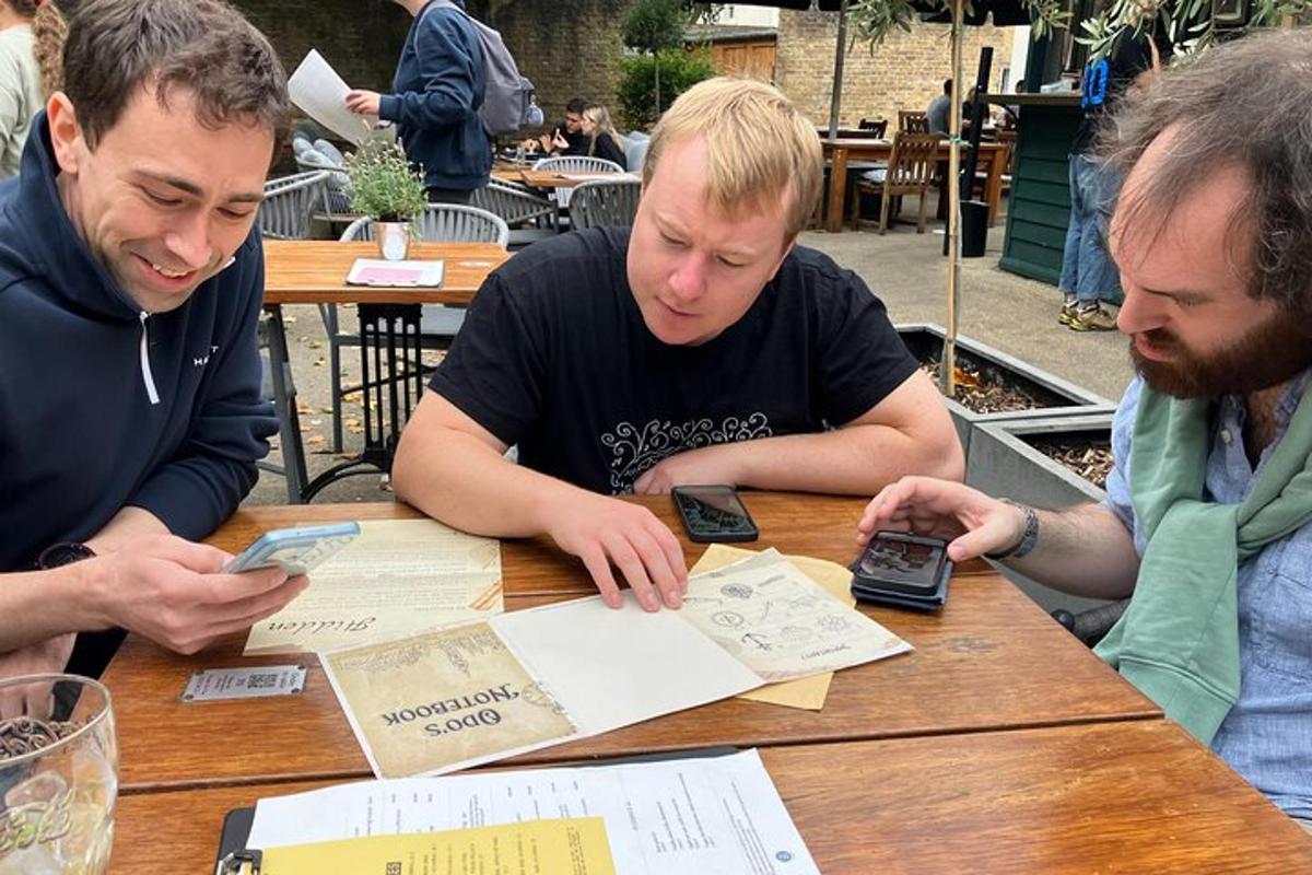 three men sitting at a table with their cell phones