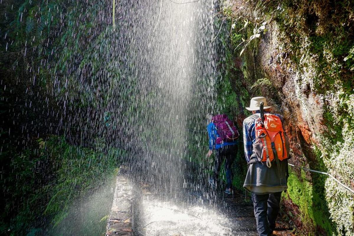 seorang lelaki dengan beg galas berjalan melalui air terjun