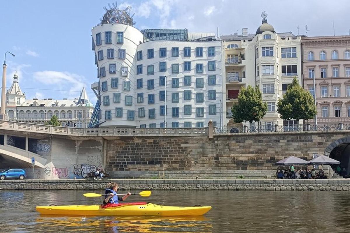 ein Junge in einem gelben Kajak in einem Fluss mit Gebäuden